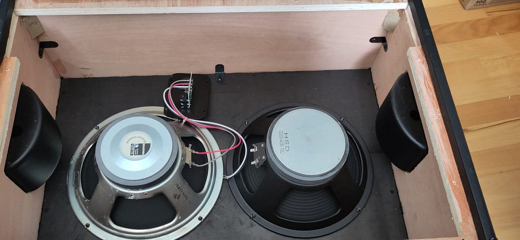 Eine Celestion G12T-75 ist in der Harley Benton G212 Gitarrenbox bereits wieder verkabelt während der zweite Stock Speaker bereits von den Kabeln gelöst wurde